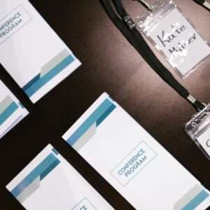 High-angle view of conference programs and name badges on a table, ideal for corporate event visuals.